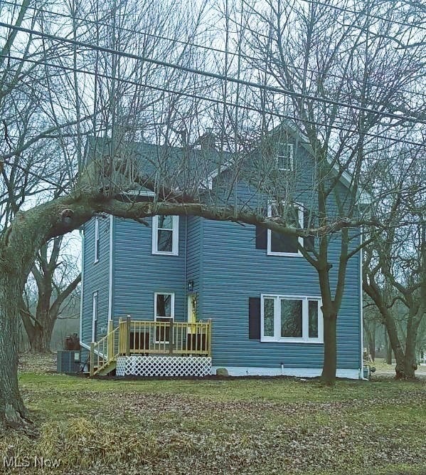 rear view of property with a yard and a deck