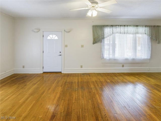 foyer entrance with crown molding, ceiling fan, and wood-type flooring