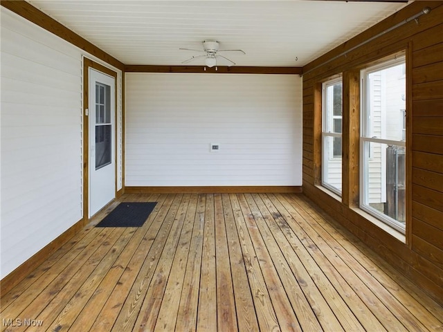 unfurnished sunroom featuring ceiling fan