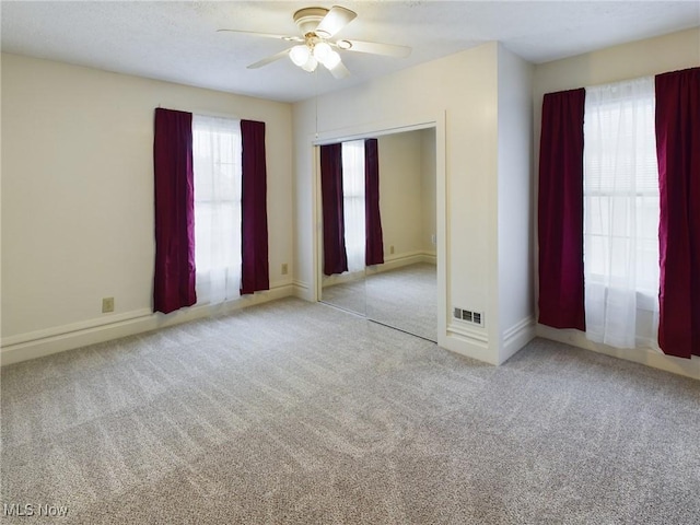 spare room featuring ceiling fan and light carpet