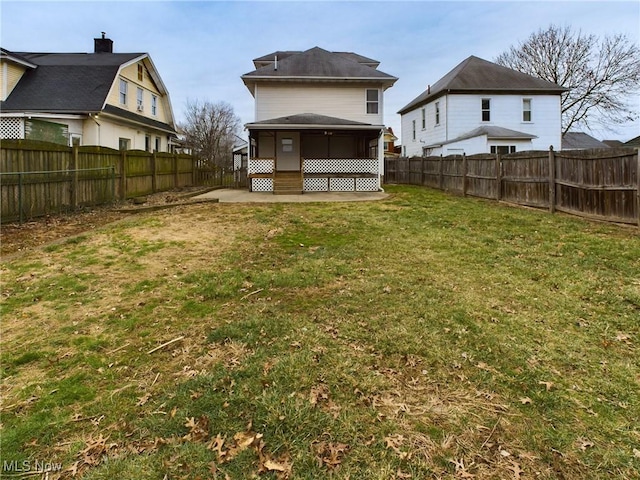 rear view of house with a patio area and a lawn