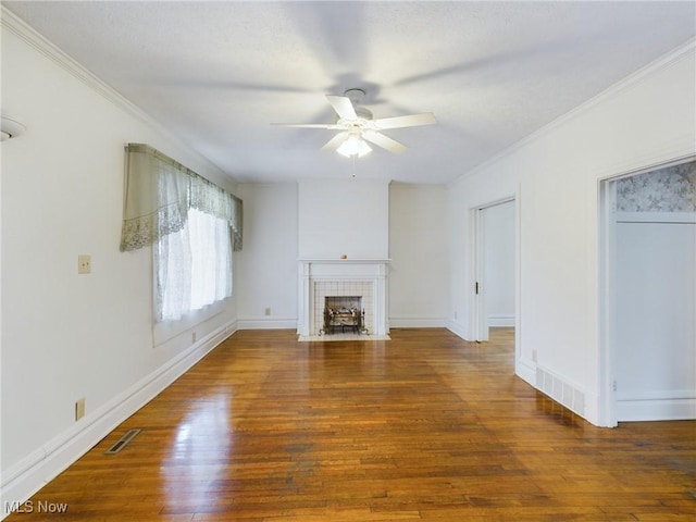 unfurnished living room with ceiling fan, a fireplace, dark hardwood / wood-style floors, and crown molding