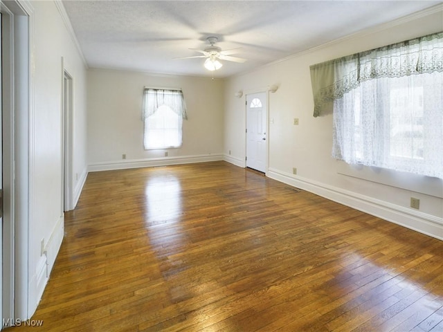 unfurnished room featuring crown molding, dark hardwood / wood-style floors, and ceiling fan