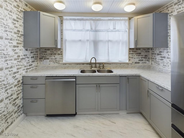 kitchen featuring sink, gray cabinets, tasteful backsplash, light stone counters, and stainless steel dishwasher