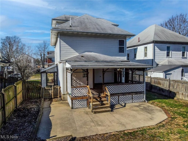 rear view of property with covered porch and a patio