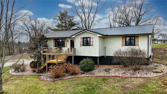 view of front of home with metal roof, a front lawn, and stairway