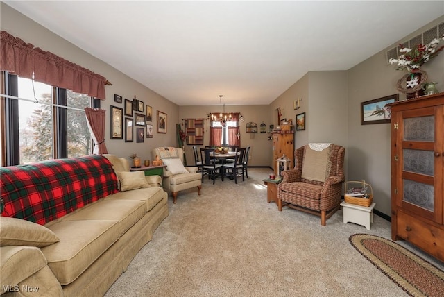 living room featuring baseboards, a chandelier, and light colored carpet