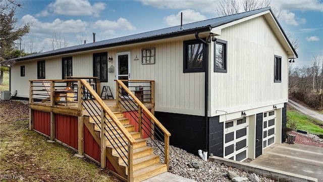 view of front of home featuring a garage, concrete driveway, metal roof, and stairs