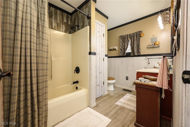 bathroom featuring a wainscoted wall, vanity, wood finished floors, crown molding, and shower / bath combination with curtain