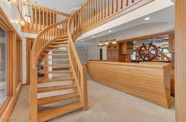 staircase with carpet and a high ceiling