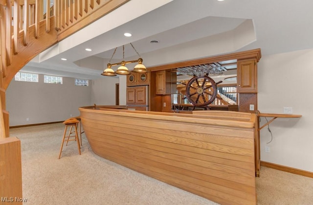 bar featuring pendant lighting, a wealth of natural light, light carpet, and a raised ceiling