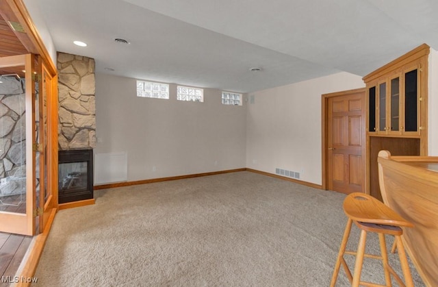 interior space with light colored carpet and a fireplace