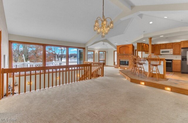 carpeted living room featuring lofted ceiling with beams and a notable chandelier