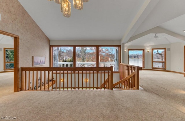 hallway featuring high vaulted ceiling, a chandelier, and carpet floors