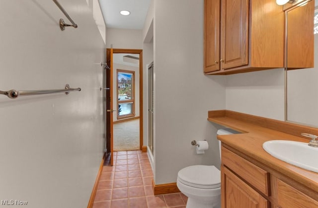 bathroom featuring a shower with door, vanity, tile patterned floors, and toilet