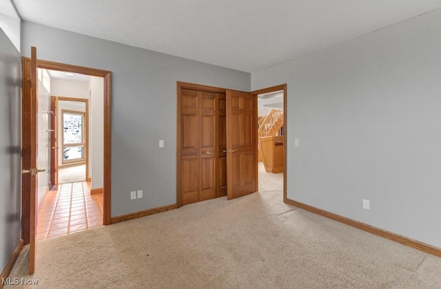 unfurnished bedroom featuring light colored carpet and a closet