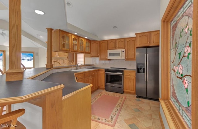 kitchen featuring stainless steel appliances, sink, decorative columns, and kitchen peninsula