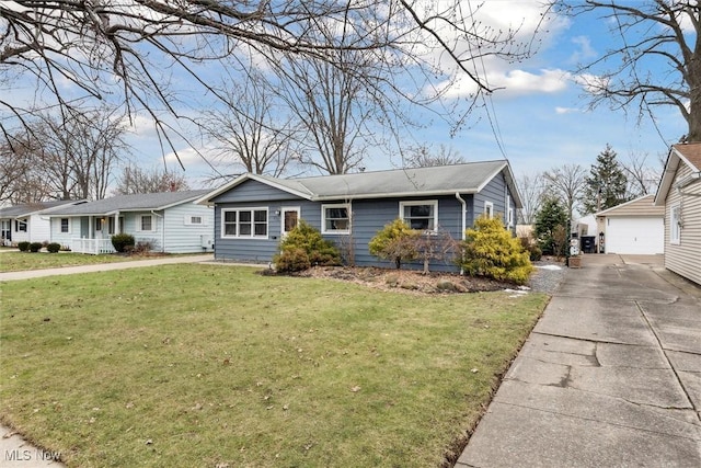 single story home with an outbuilding, a garage, and a front lawn