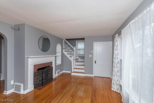 unfurnished living room with hardwood / wood-style floors and a fireplace