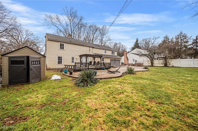 rear view of property with a deck, a lawn, a pergola, a gazebo, and a storage shed