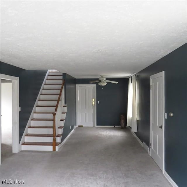 interior space with ceiling fan and a textured ceiling