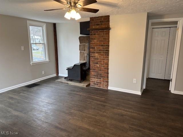 unfurnished living room with ceiling fan, dark hardwood / wood-style floors, and a textured ceiling