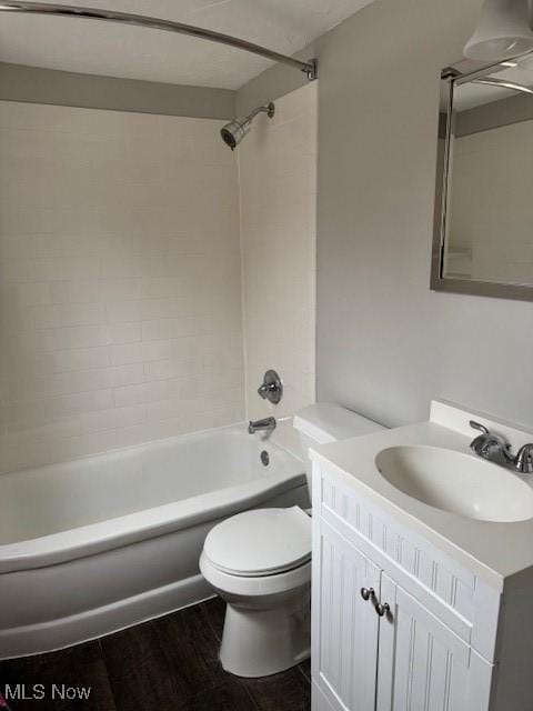 full bathroom featuring tiled shower / bath, vanity, toilet, and hardwood / wood-style floors