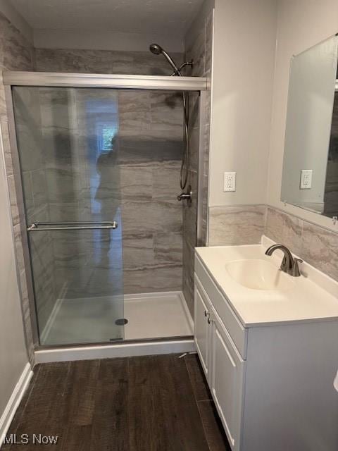 bathroom with vanity, hardwood / wood-style floors, and a shower with shower door