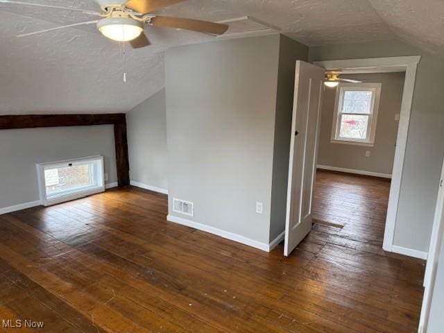 bonus room with lofted ceiling, ceiling fan, dark hardwood / wood-style flooring, and a textured ceiling