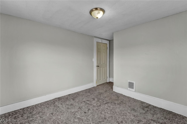 carpeted empty room featuring a textured ceiling