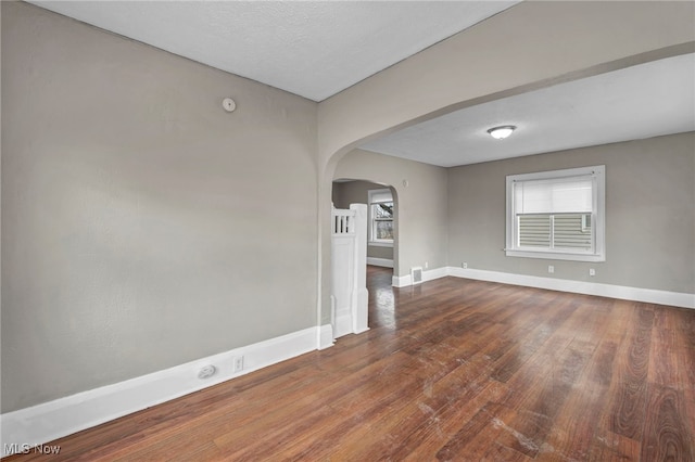 unfurnished room featuring wood-type flooring and a textured ceiling