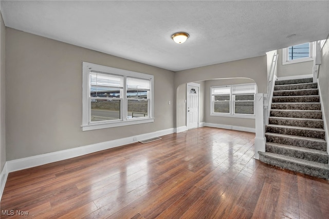 empty room featuring a textured ceiling and dark hardwood / wood-style flooring