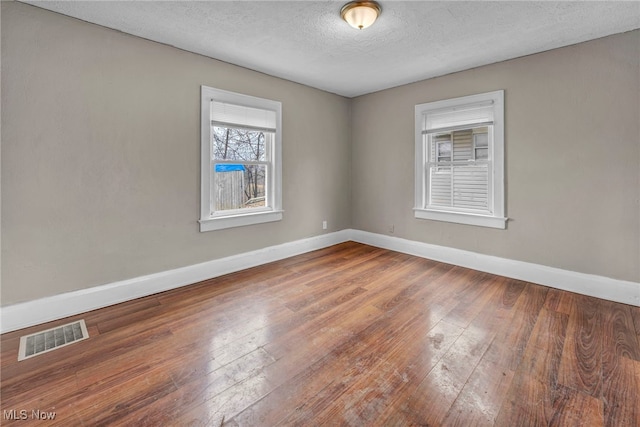 empty room featuring hardwood / wood-style flooring and a textured ceiling