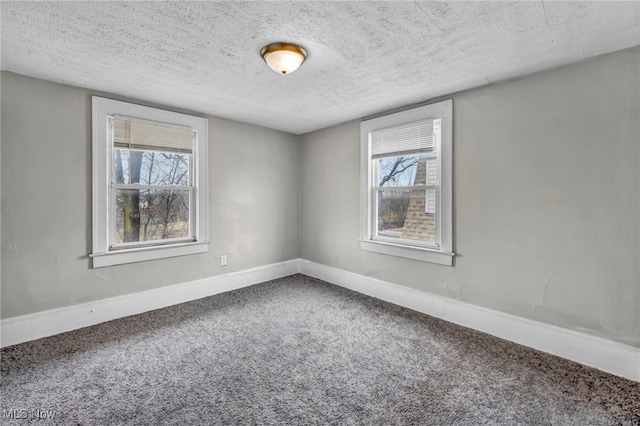 carpeted spare room with plenty of natural light and a textured ceiling