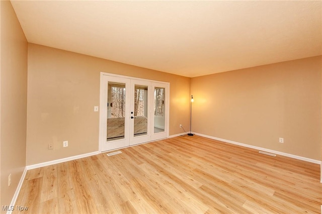 spare room featuring wood-type flooring and french doors