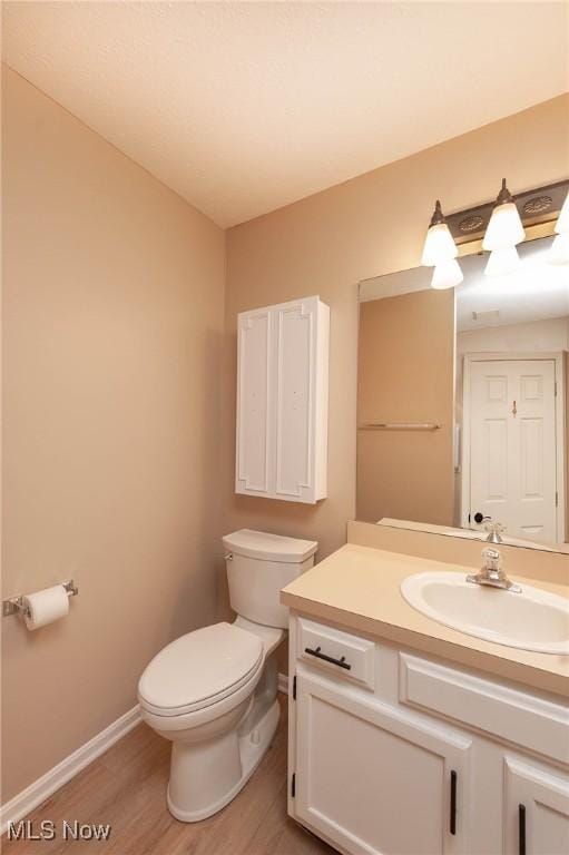 bathroom featuring hardwood / wood-style flooring, vanity, and toilet