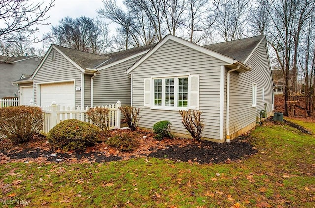 view of front of house with a garage, a front lawn, and central air condition unit