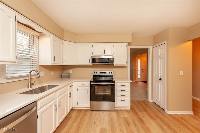 kitchen featuring stainless steel appliances, sink, and white cabinets