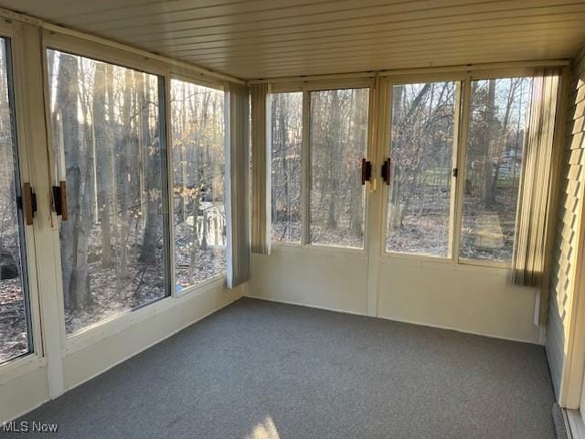 unfurnished sunroom with wooden ceiling and a wealth of natural light