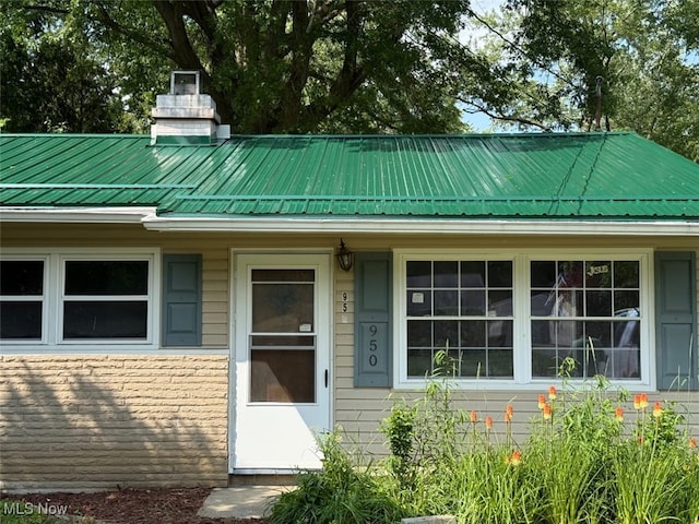 950 Donmar Ln, Boardman, OH 44511 - view of exterior entry with a metal roof and a chimney