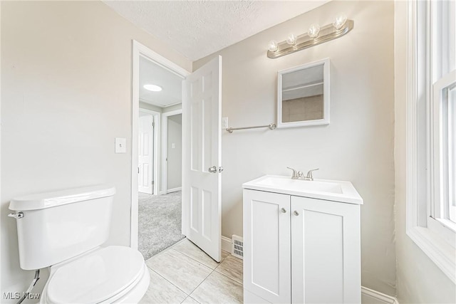 bathroom featuring vanity, toilet, and a textured ceiling