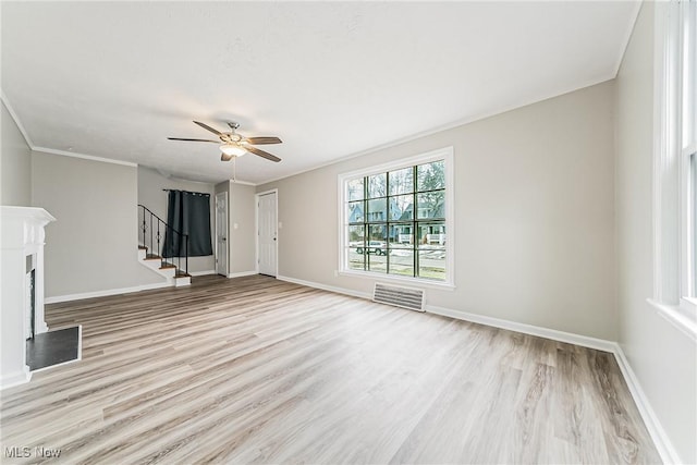 unfurnished living room featuring ceiling fan, ornamental molding, and light wood-type flooring