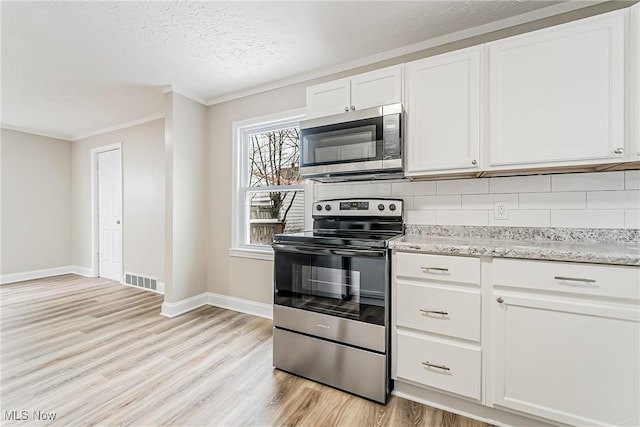 kitchen featuring white cabinetry, tasteful backsplash, stainless steel appliances, and light wood-type flooring