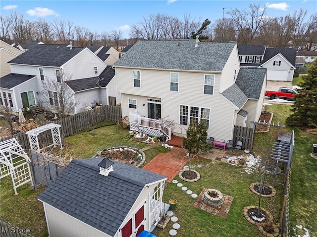 rear view of property with a yard and a fire pit