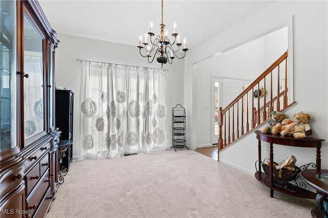 carpeted foyer entrance featuring an inviting chandelier