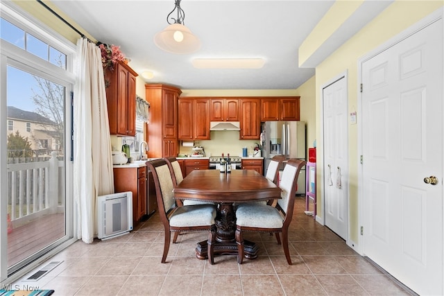 dining room with radiator heating unit, sink, and light tile patterned floors