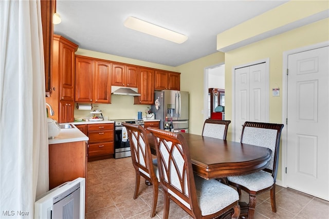 kitchen with appliances with stainless steel finishes, sink, and light tile patterned floors