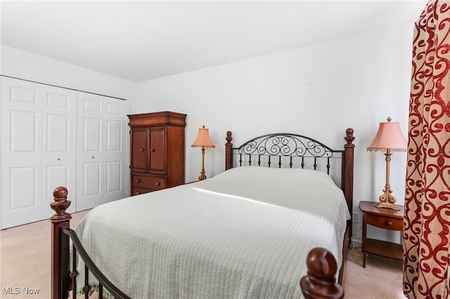 bedroom featuring light colored carpet and a closet