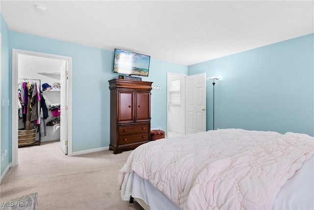 carpeted bedroom featuring a walk in closet and a closet