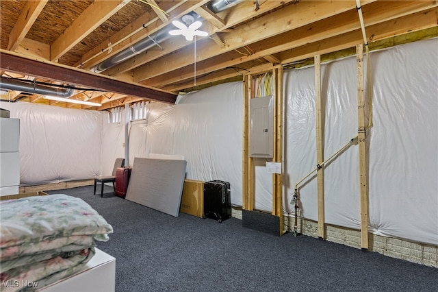 basement with dark carpet, electric panel, and white fridge